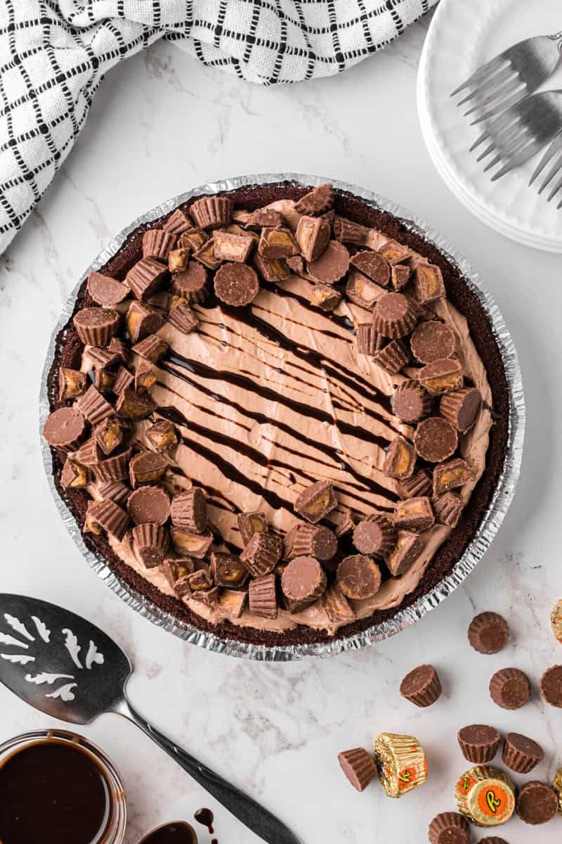 Reese's Pie topped with chocolate sauce drizzle and mini Reese's cups.