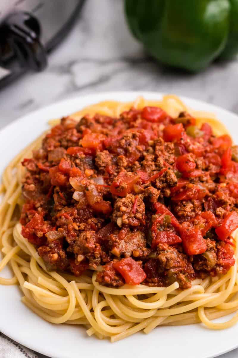 closeup of the slow cooker spaghetti sauce on top of spaghetti.