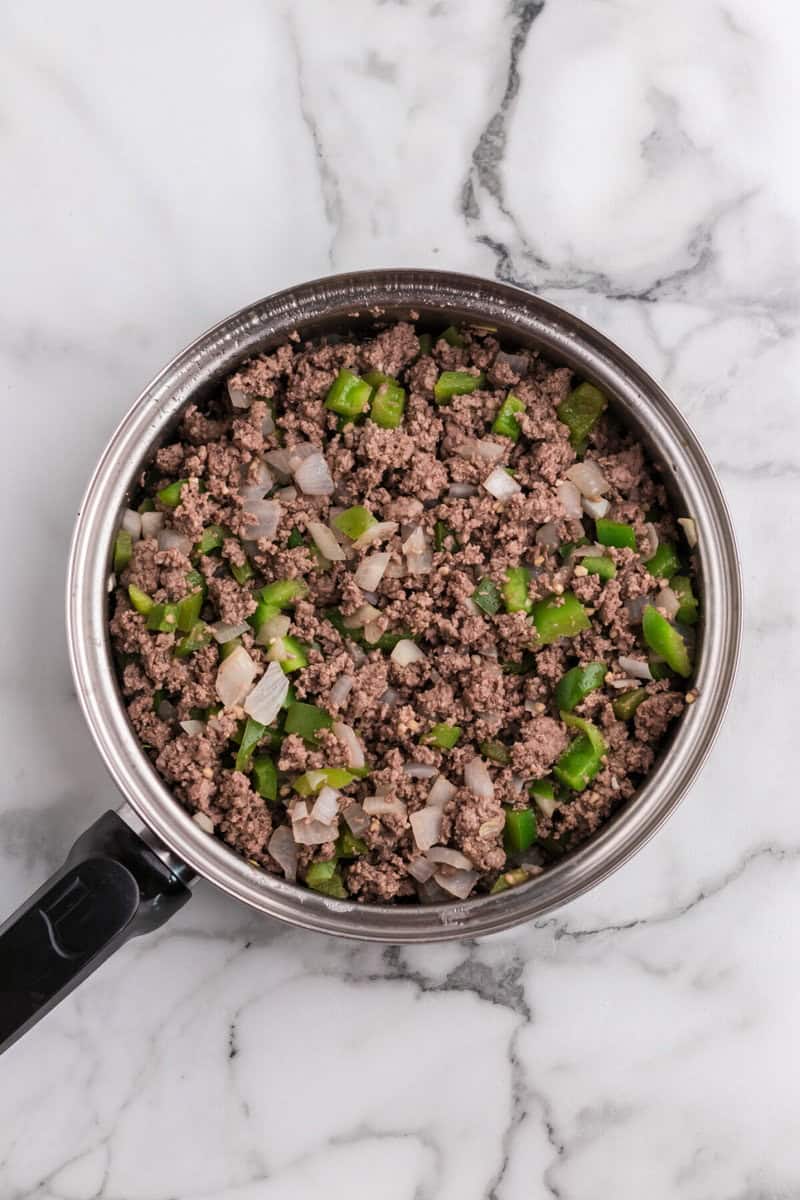 cooked ground beef, peppers and onions in pan.