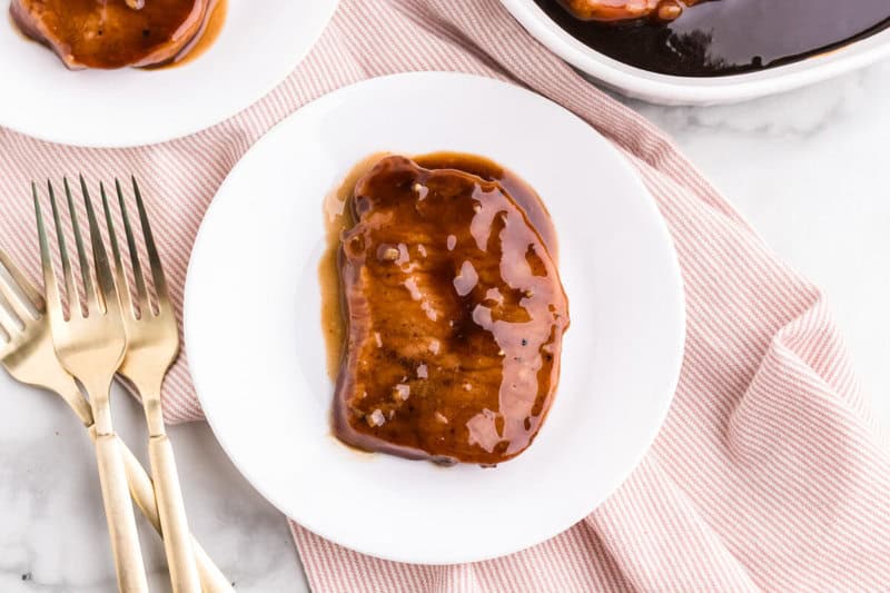 closeup of the teriyaki pork chops on a white plate.