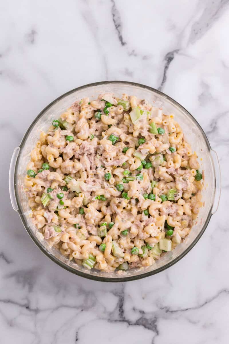 macaroni salad mixed with the dressing in large glass bowl.