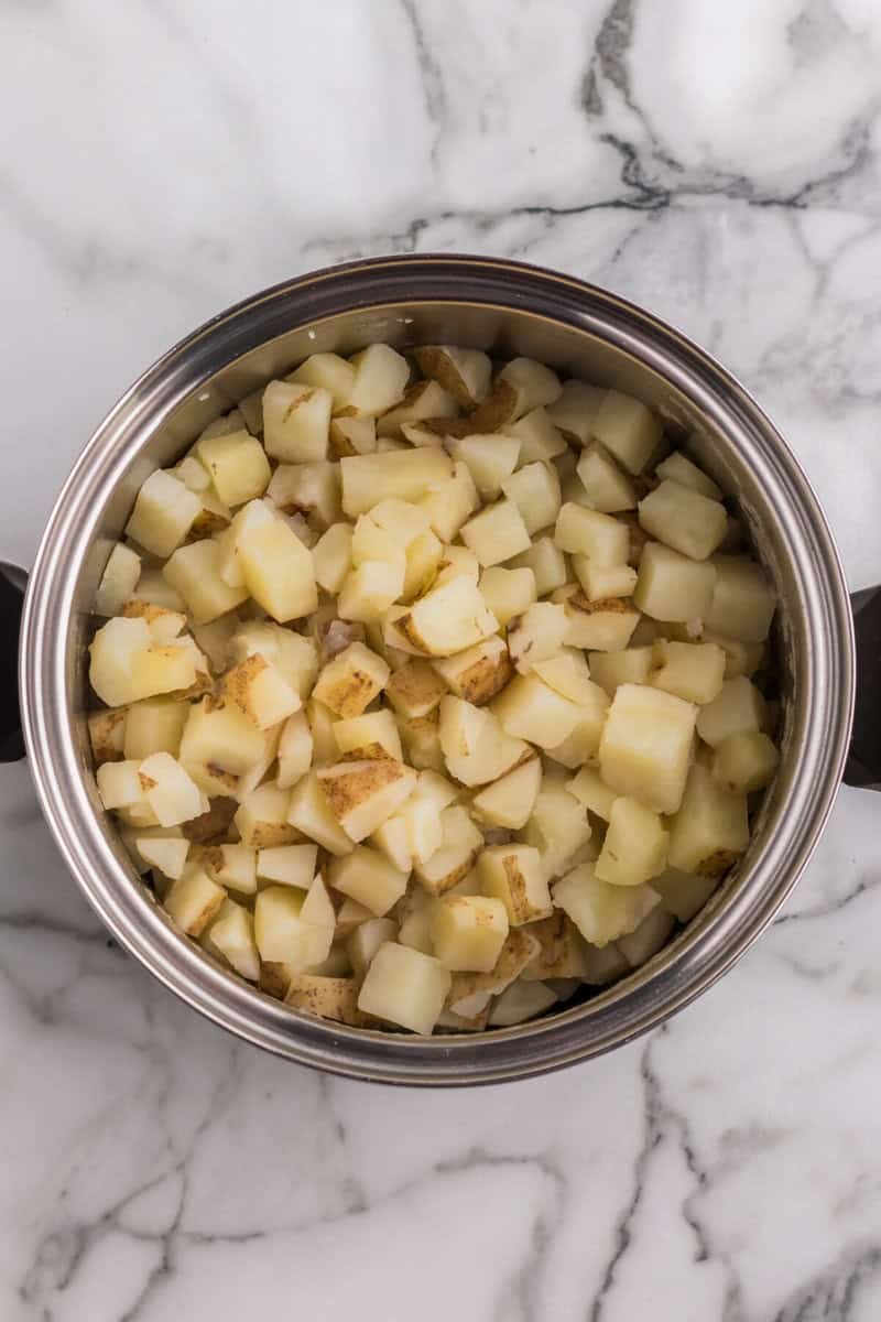 diced and cubed potatoes in pot to be boiled.