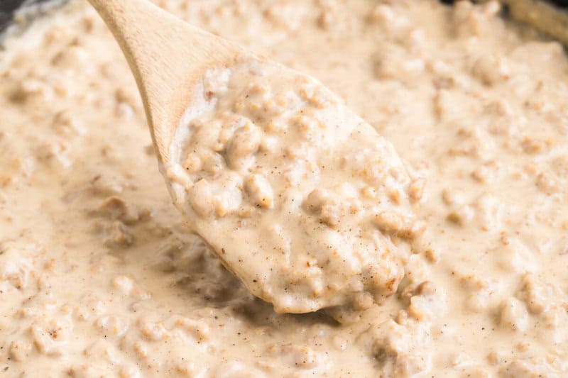 closeup of the Sausage Gravy being served with a wooden spoon.