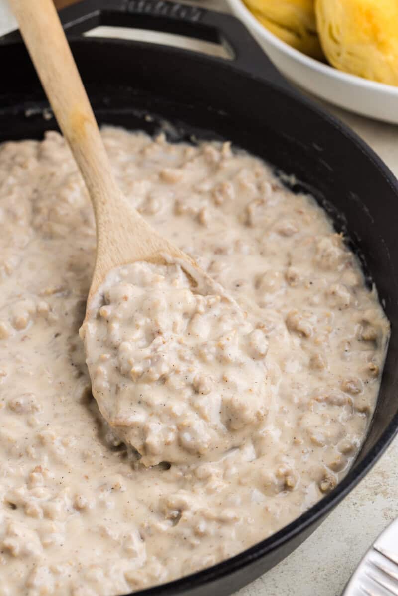 serving the gravy with a wooden spoon.