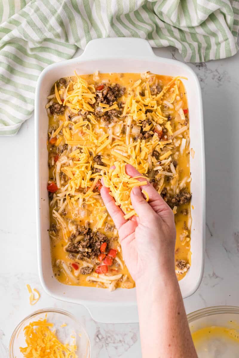 topping the casserole with cheese before baking.