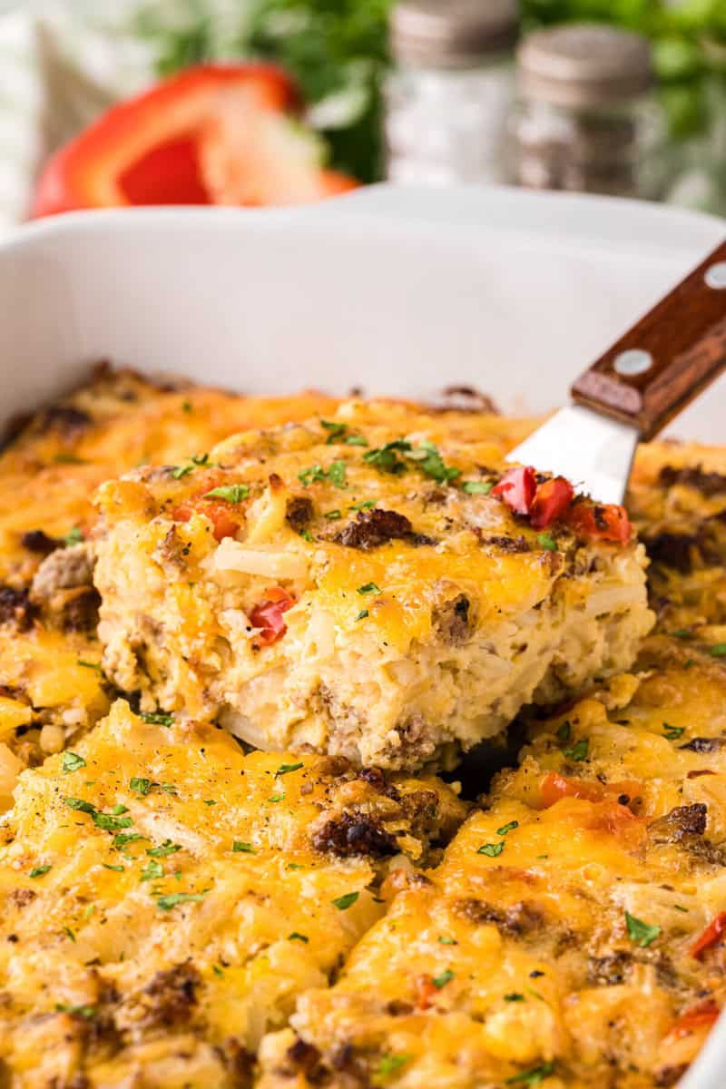 serving a slice of the breakfast casserole.