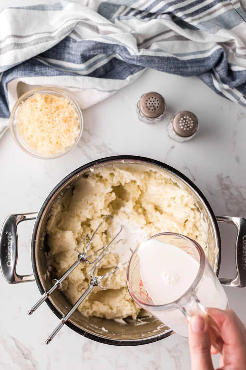adding the garlic infused half and half to the mashed potatoes.