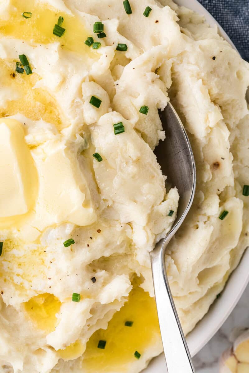 serving the garlic mashed potatoes with a silver spoon.