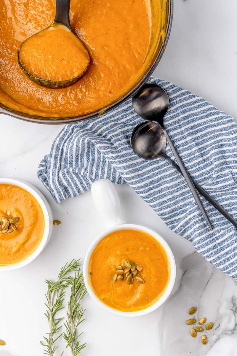 butternut squash soup served in two white bowls.