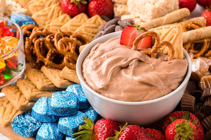 chocolate fudge dip in white bowl on charcuterie board.