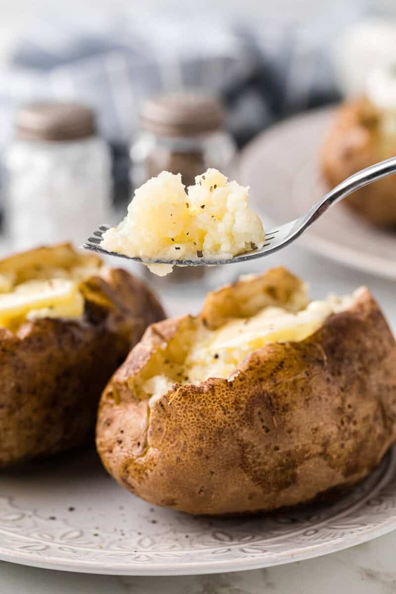 eating the baked potato with a fork.