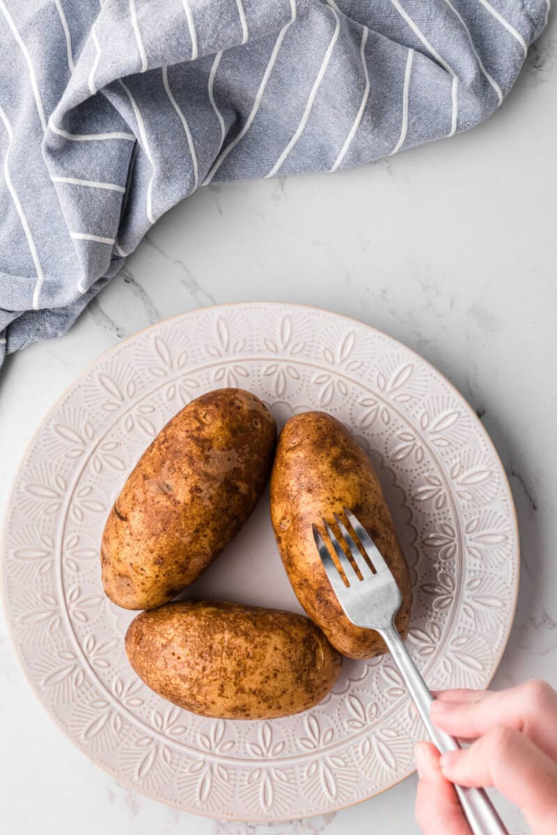 poking potatoes with a fork before cooking.