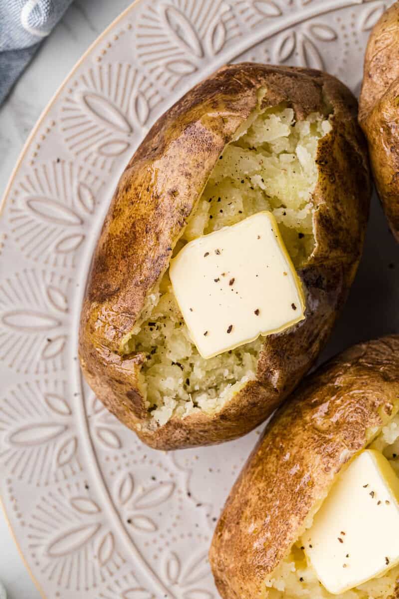 closeup of a baked potato with a slab of butter on top.