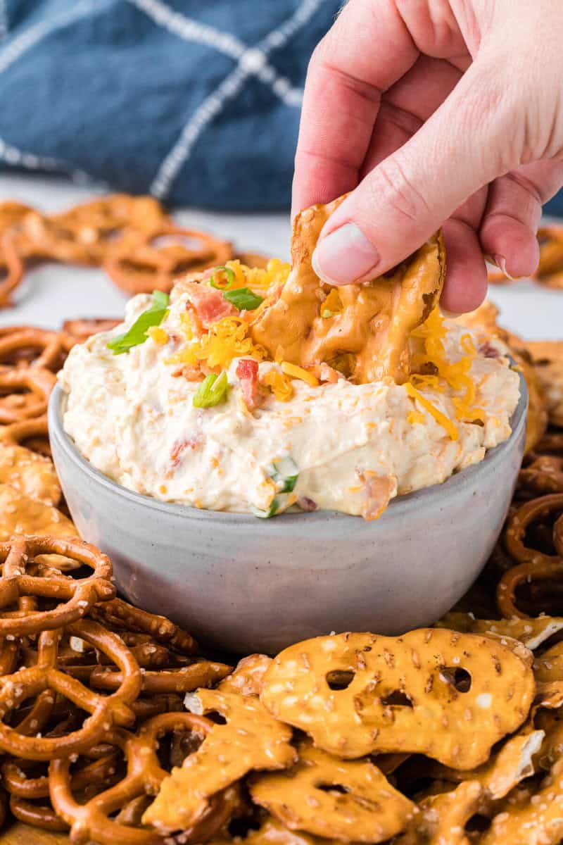 dipping a pretzel into the dip.