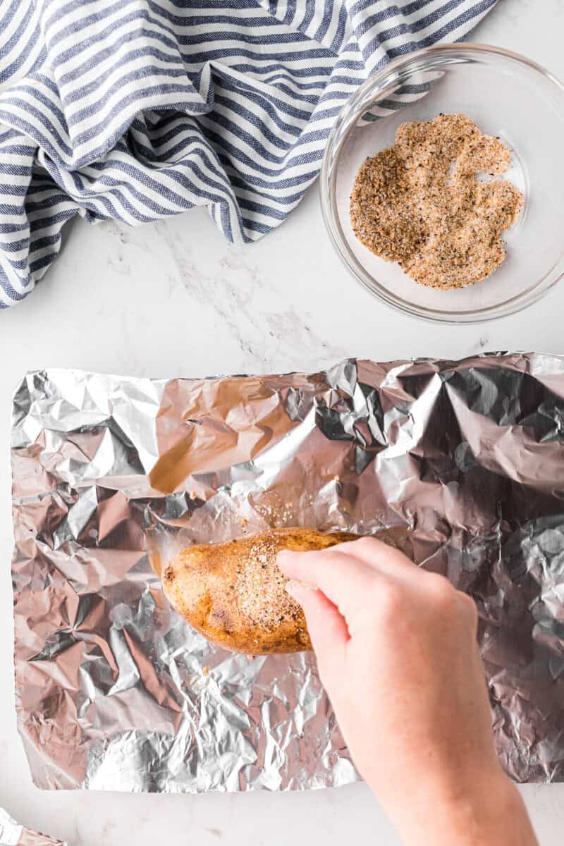 seasoning the potatoes before baking.