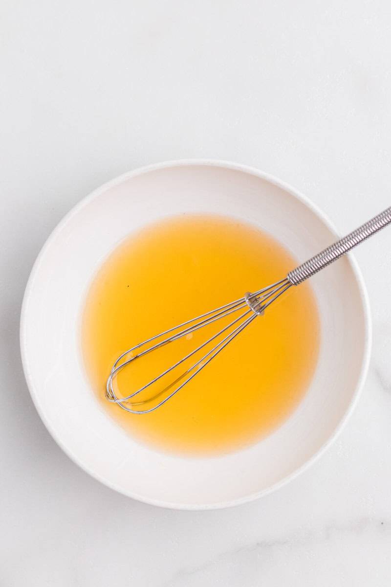 whisking together the honey and lime juice to make the dressing.