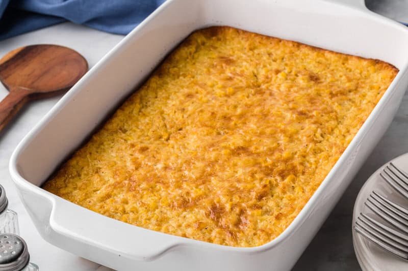 closeup of the corn pudding baked in a white casserole dish.