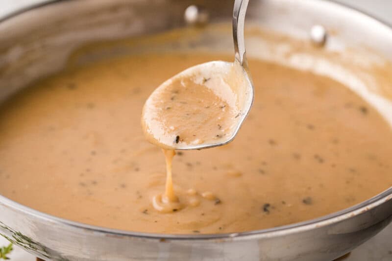 using a small ladle to serve the gravy.