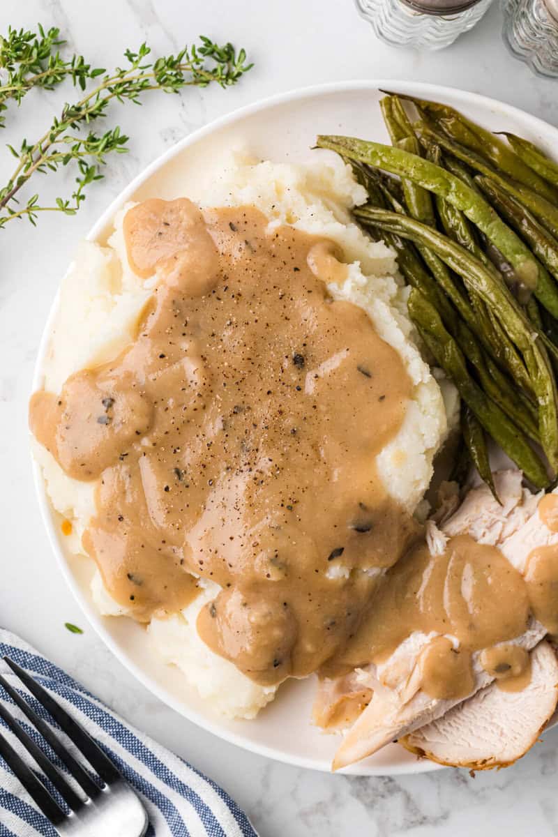 gravy poured over mashed potatoes and turkey.
