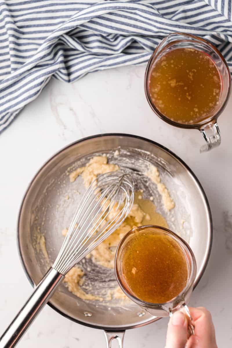 adding the drippings to the gravy and whisking it together.