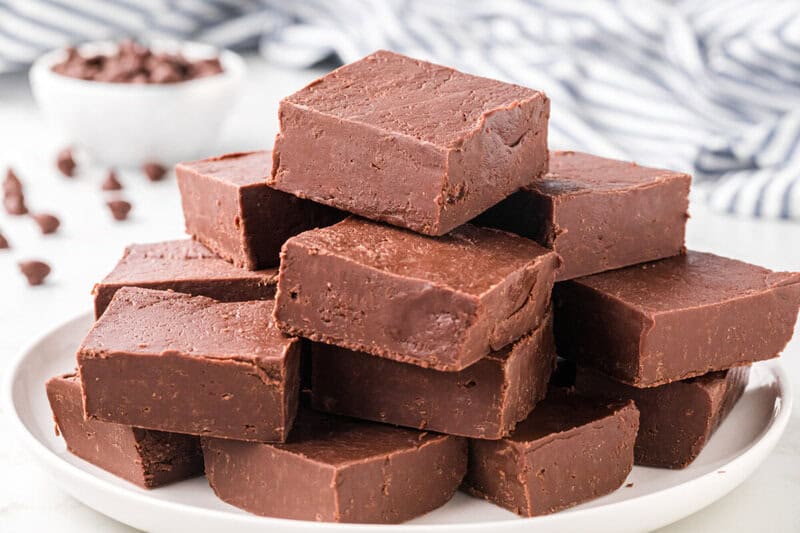 slices of the fudge stacked on top of each other on a white plate.