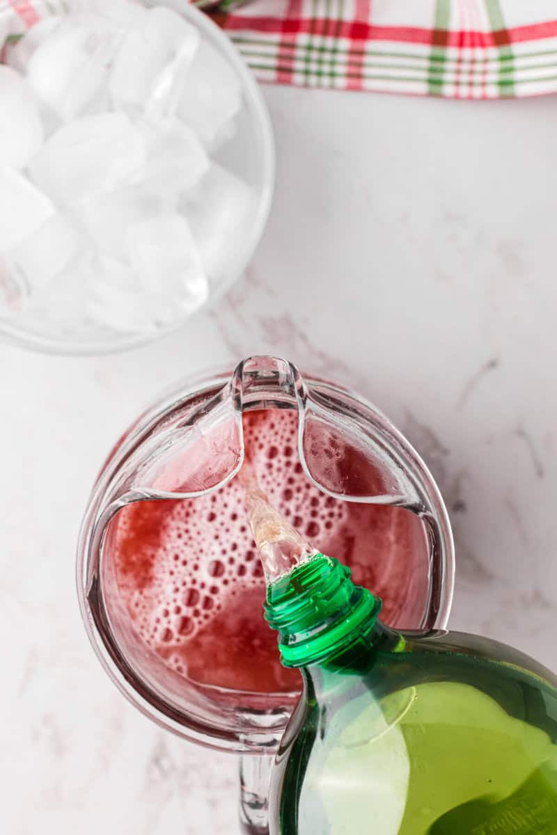 pouring the ginger ale into the punch.