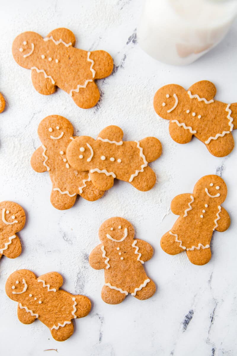 many gingerbread men decorated and laid out on the counter top.