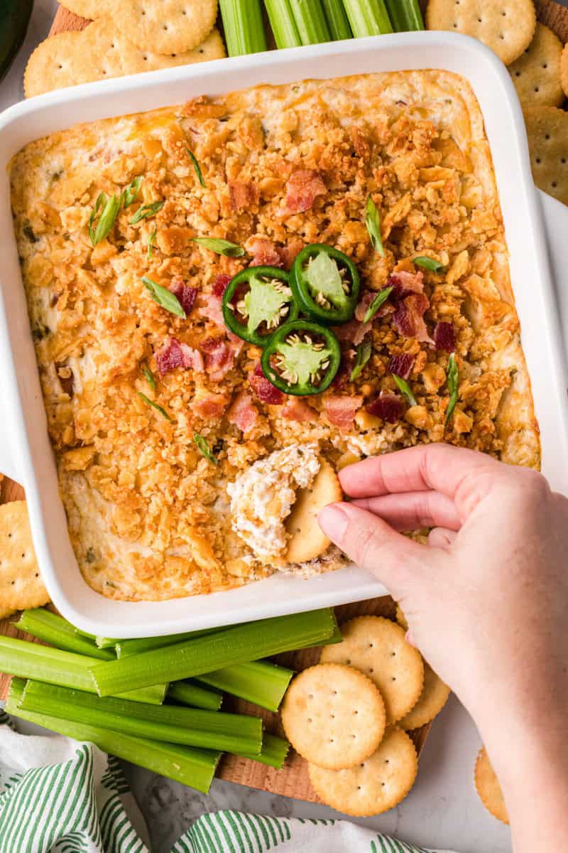 top-down view of the Jalapeno Popper Dip with a Ritz Cracker dipped into it.