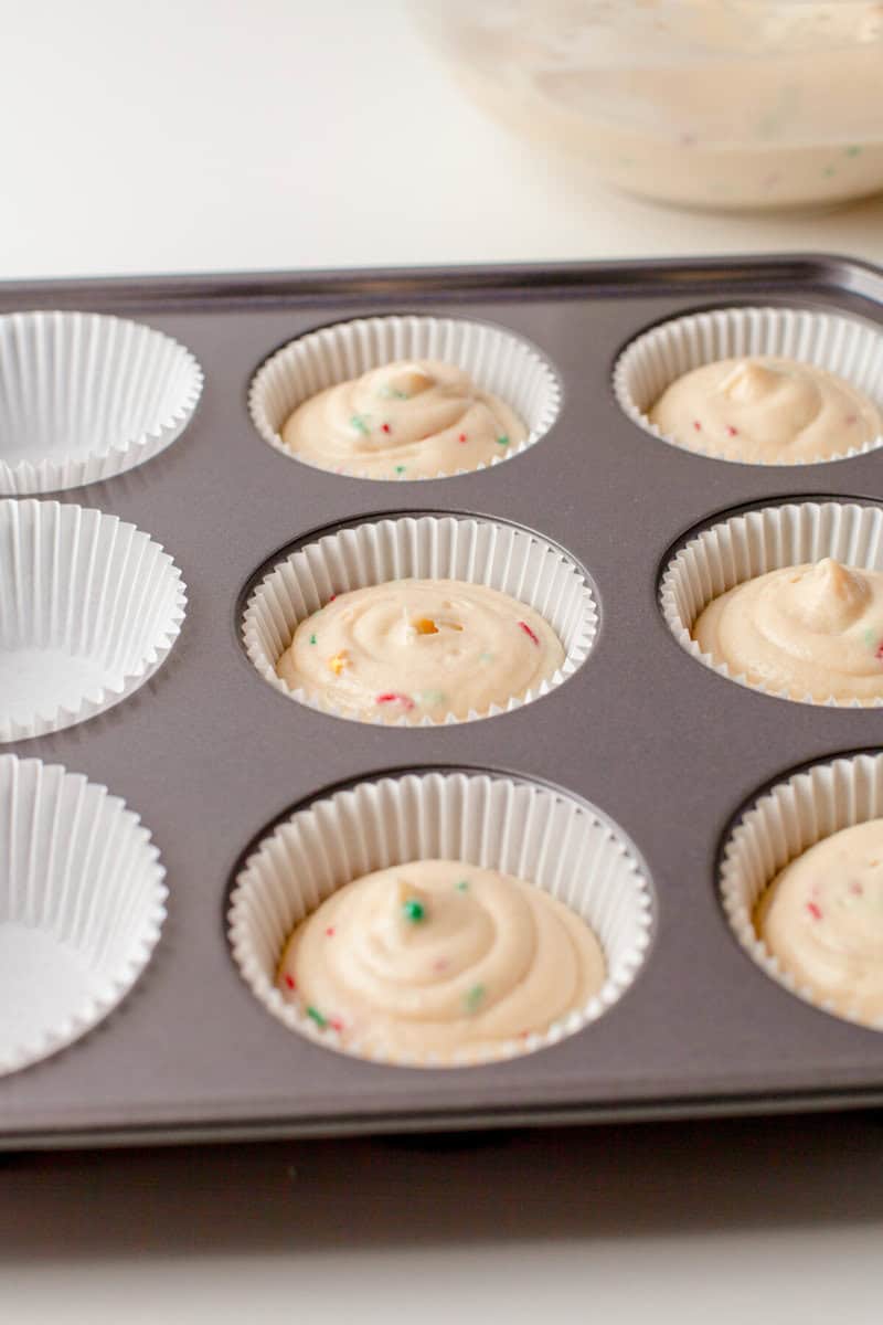 cupcake batter in cupcake liners in a cupcake baking pan.