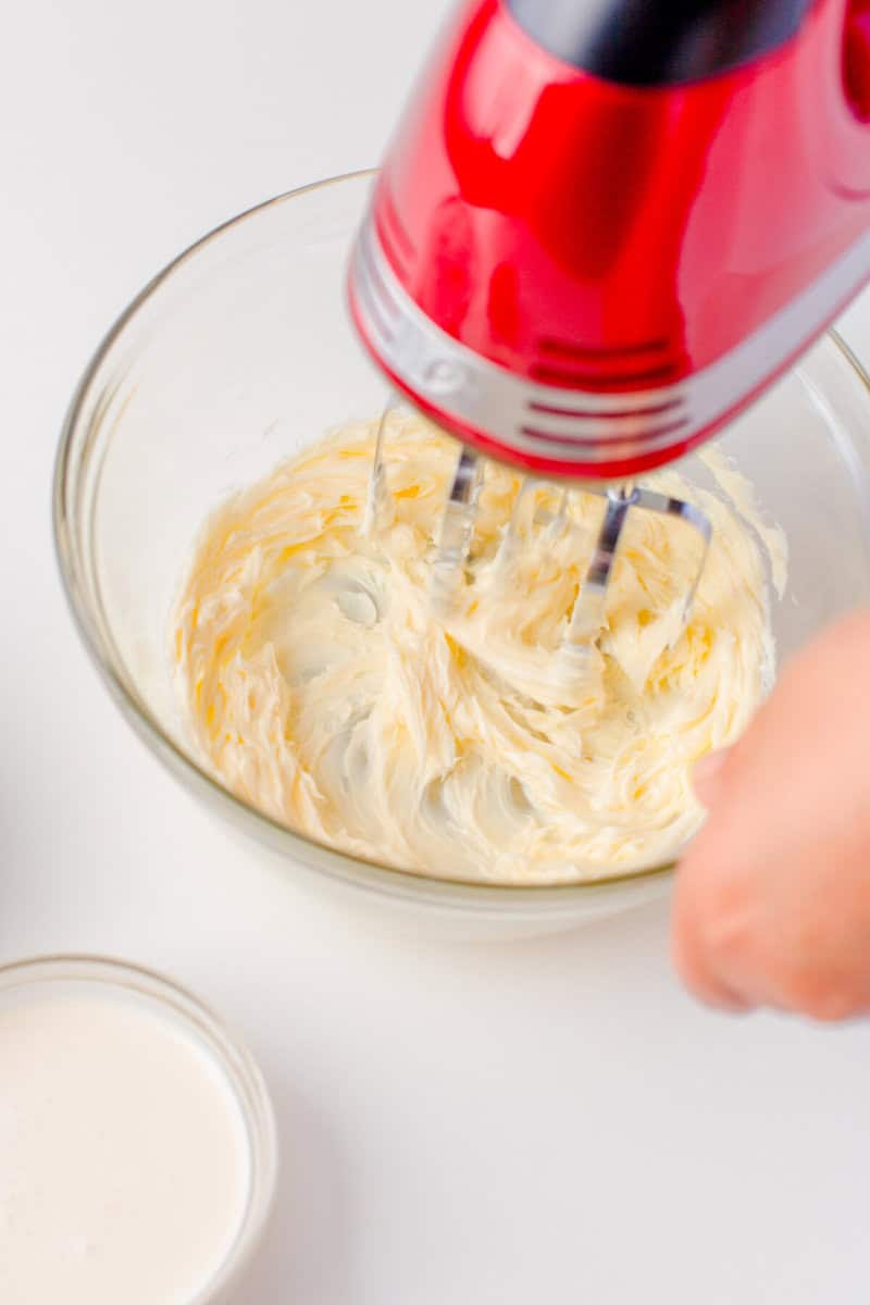 mixing the frosting with a hand mixer.