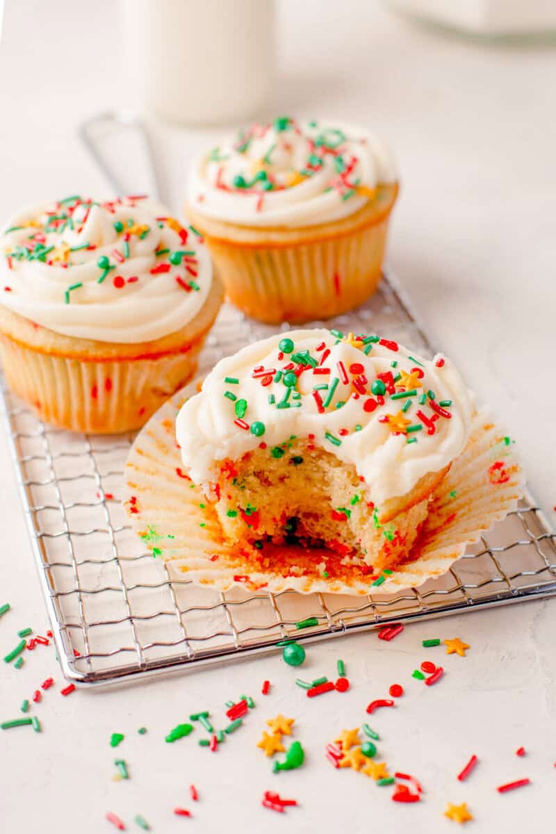 Three Christmas Cupcakes on white rack decorated.