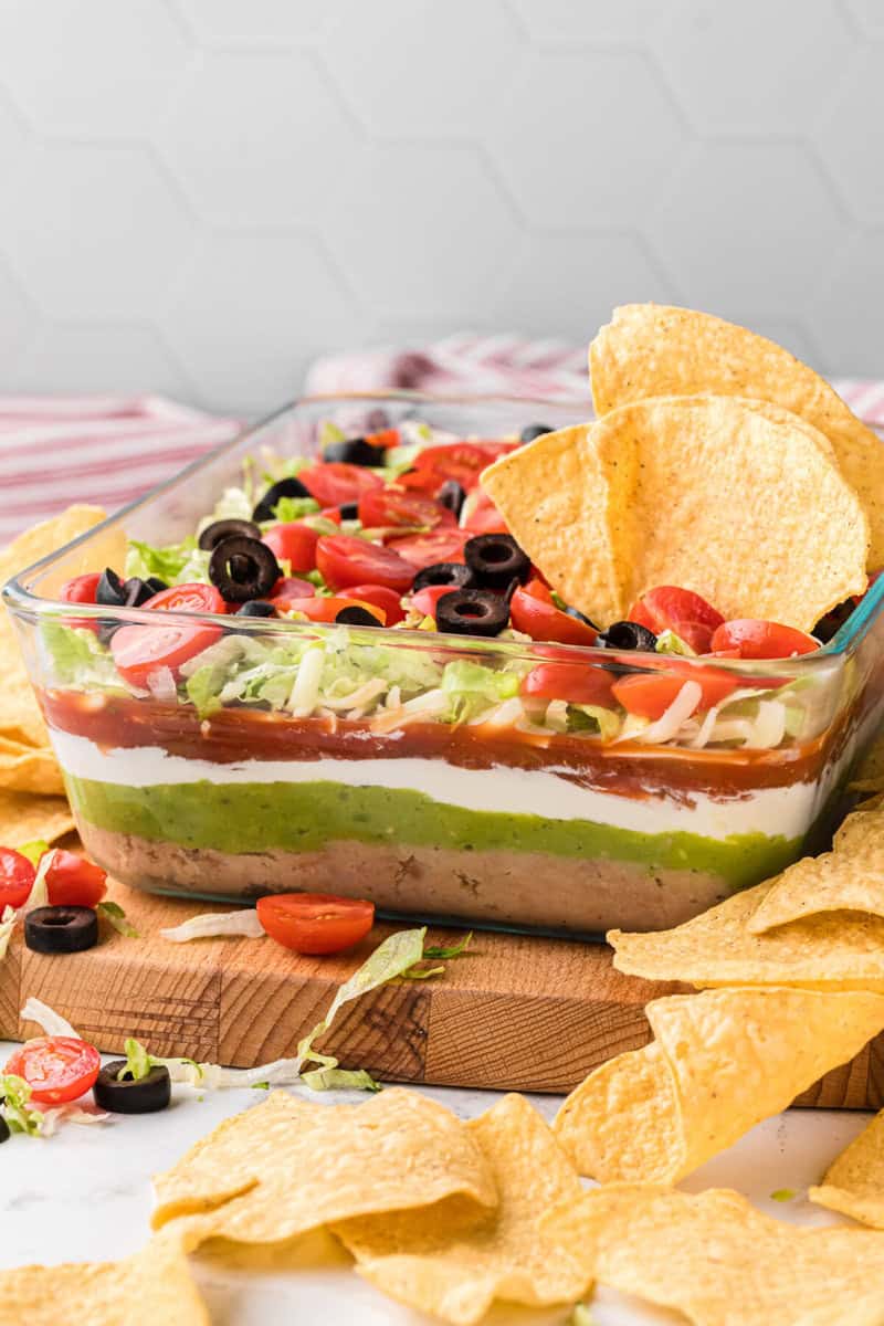 7 Layer Dip being served with tortilla chips.