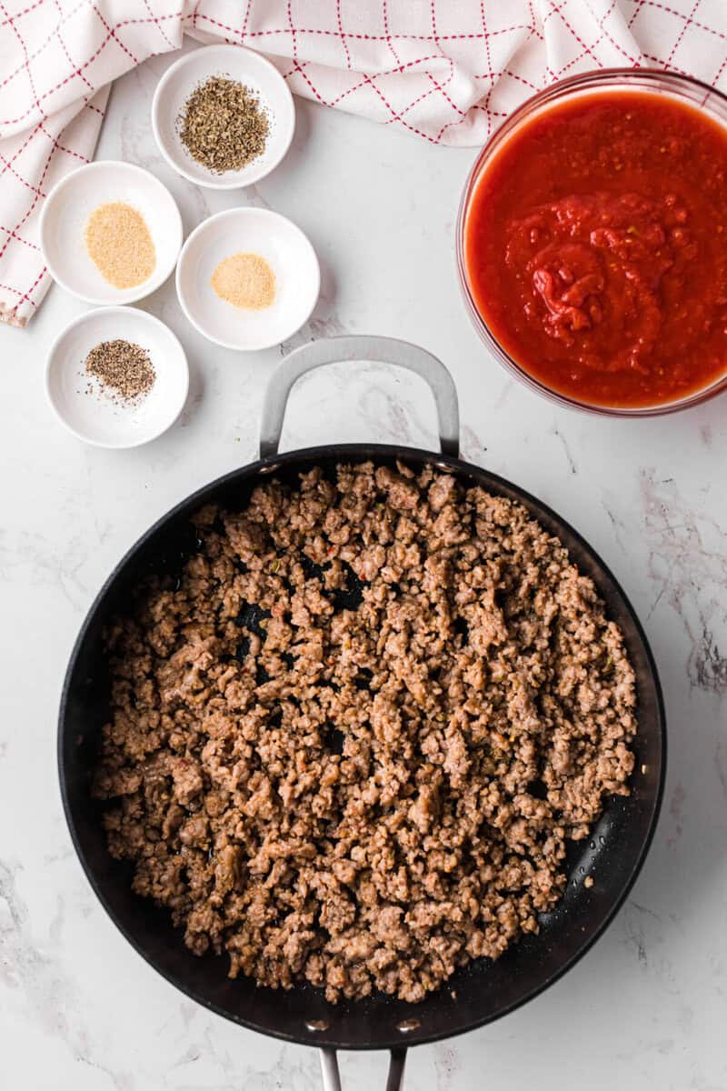 cooking the meat in a skillet to make the sauce.