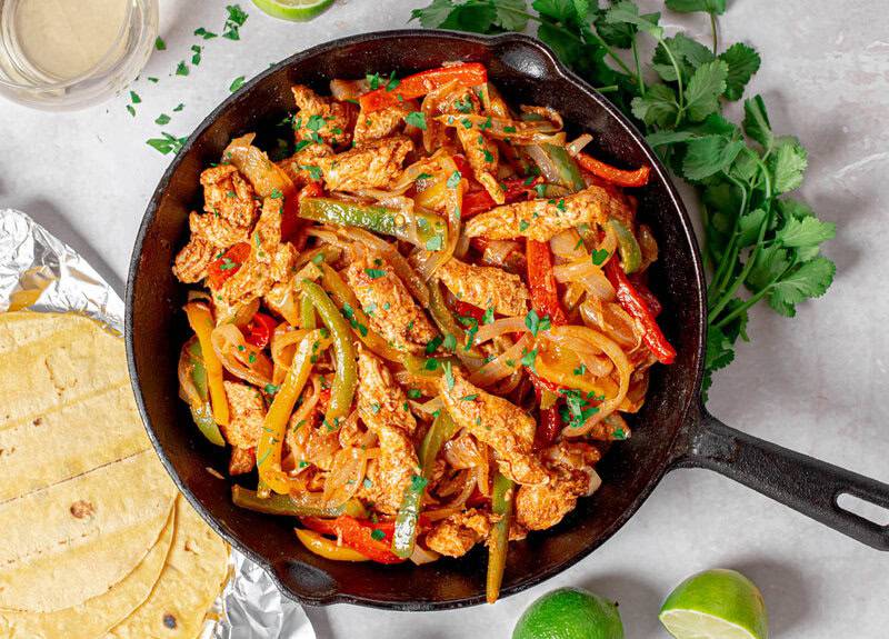 Chicken Fajitas cooked in a skillet.