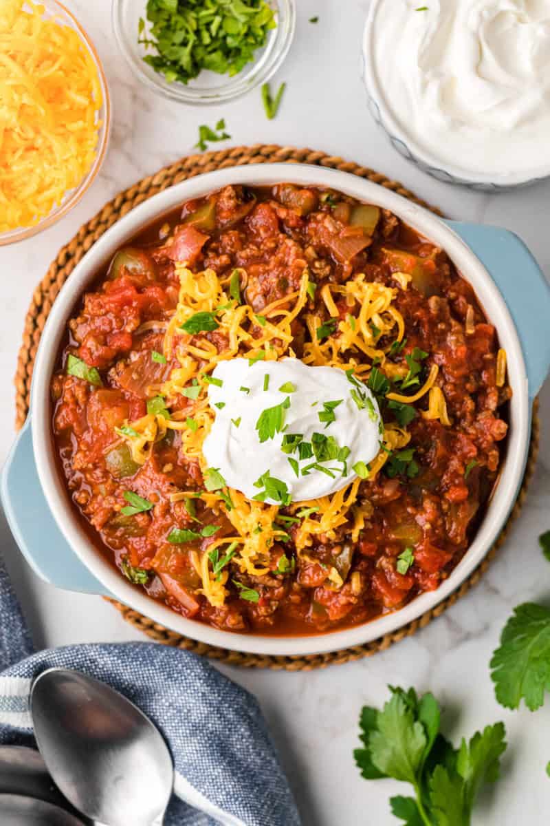 No Bean Chili served with sour cream, cheese and parsley on top.