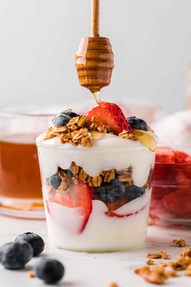 drizzling some honey over top of the parfait.