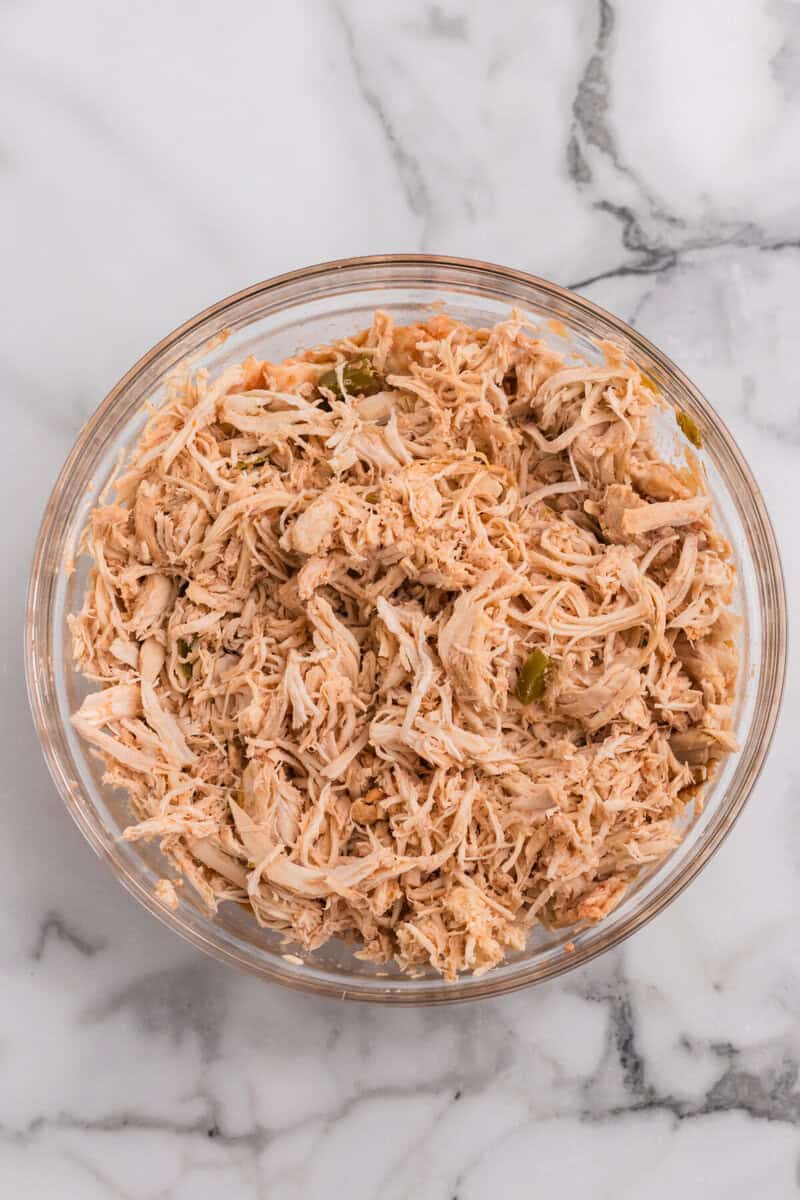 chicken shredded in a large glass bowl.