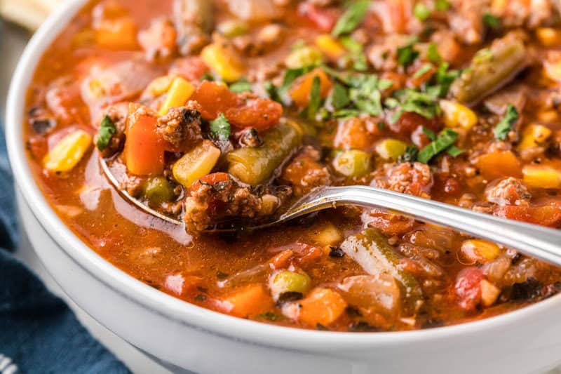 closeup of the vegetable beef soup in a white bowl.