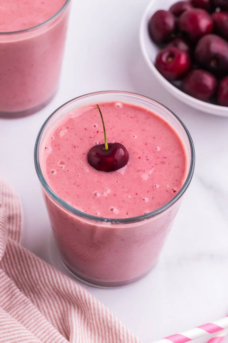 top-down view of the cherry smoothie with a cherry on top.