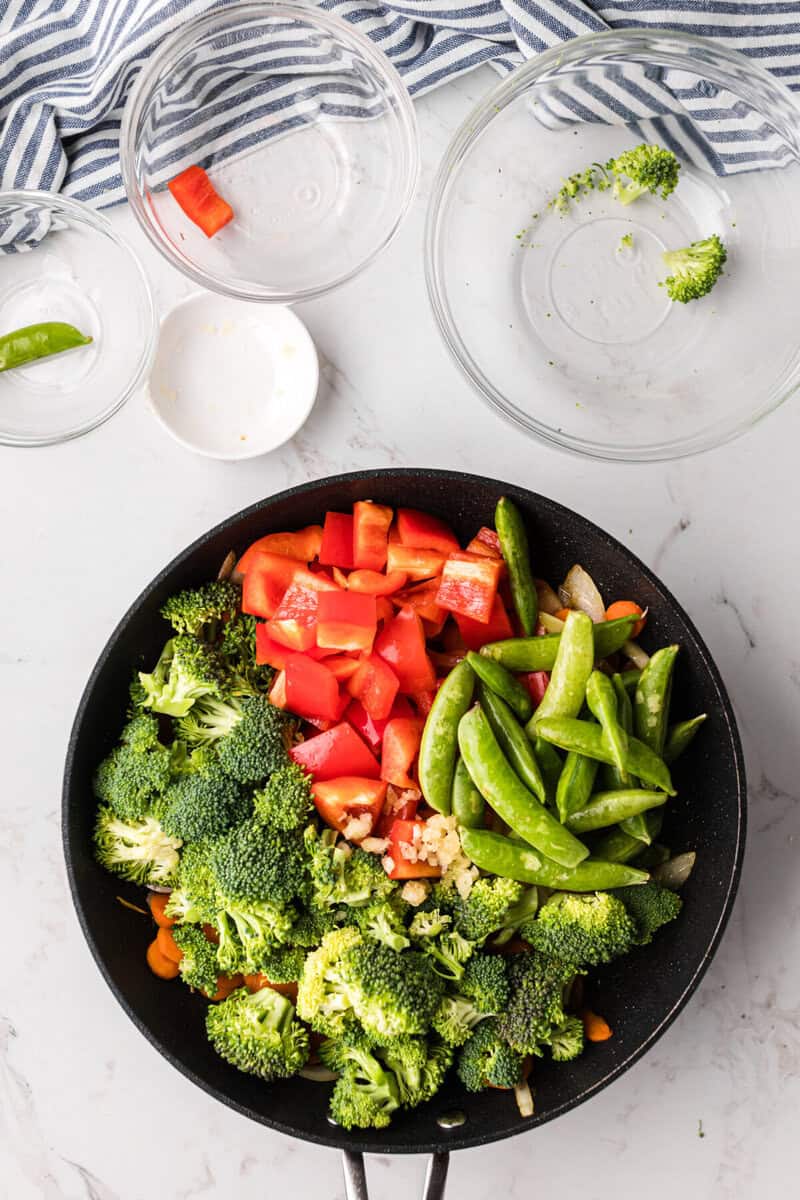 adding the other veggies to the skillet to cook them.