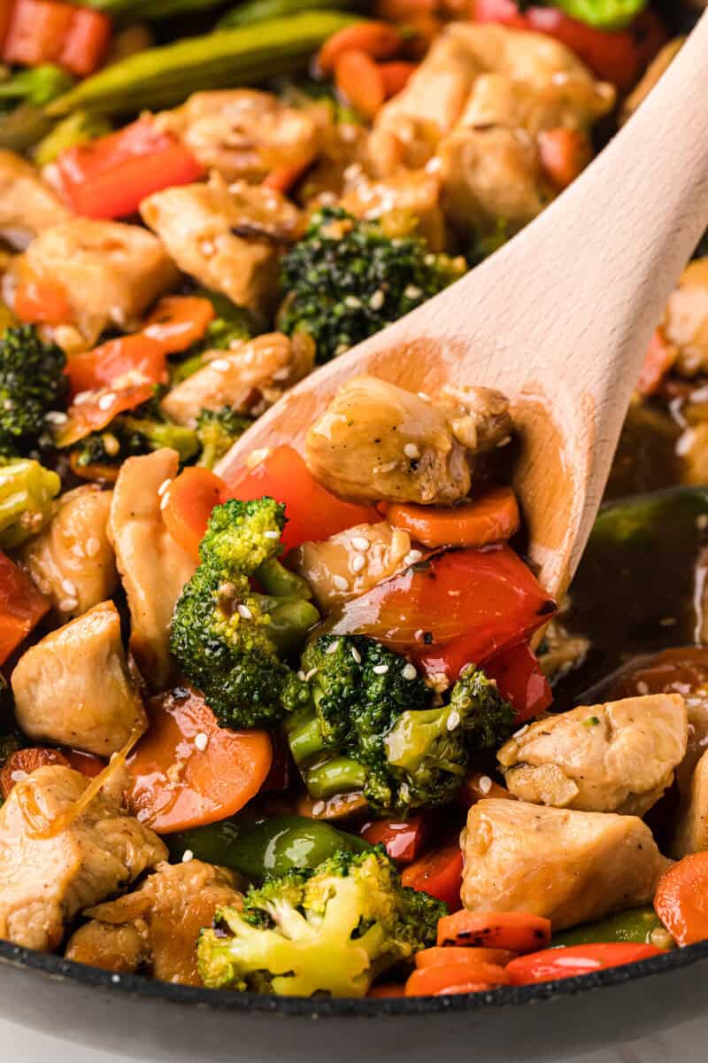 closeup of the Chicken Stir Fry being served with a wooden spoon.