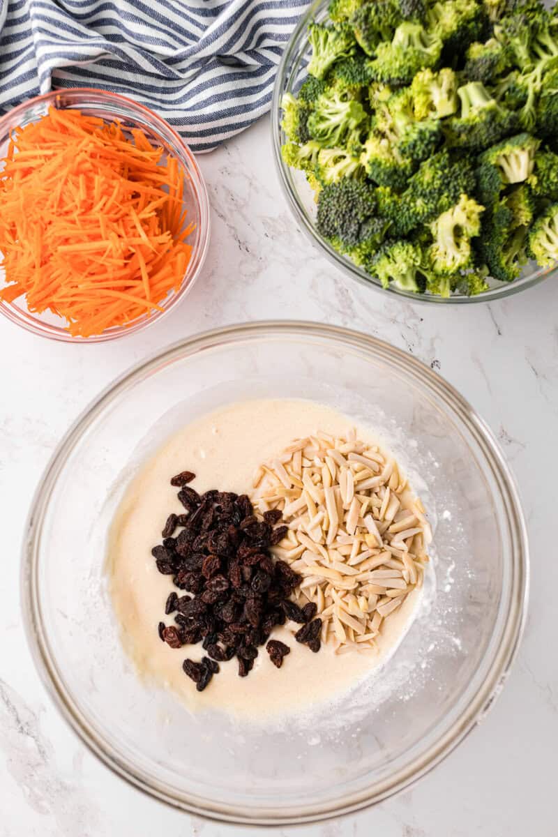 mixing together the dressing, almonds, and raisins in a large glass bowl.