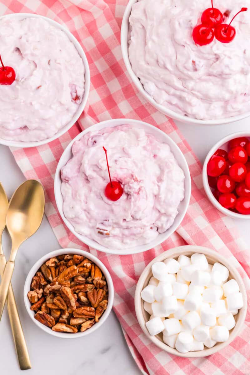 3 bowls of the Cherry Fluff with ingredients for the Fluff in bowls around it.