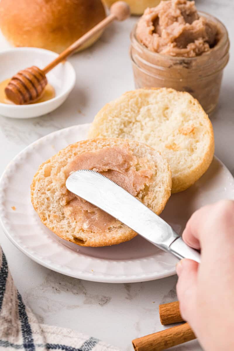 spreading the butter on a biscuit.