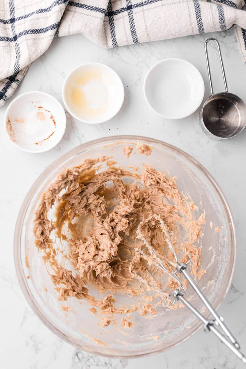 using a hand mixer to blend all ingredients together to make the butter.