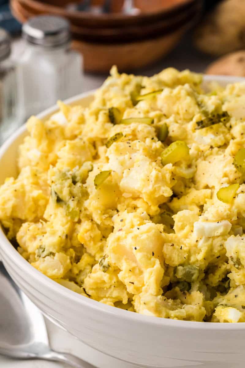 closeup of the finished potato salad in a white serving bowl.
