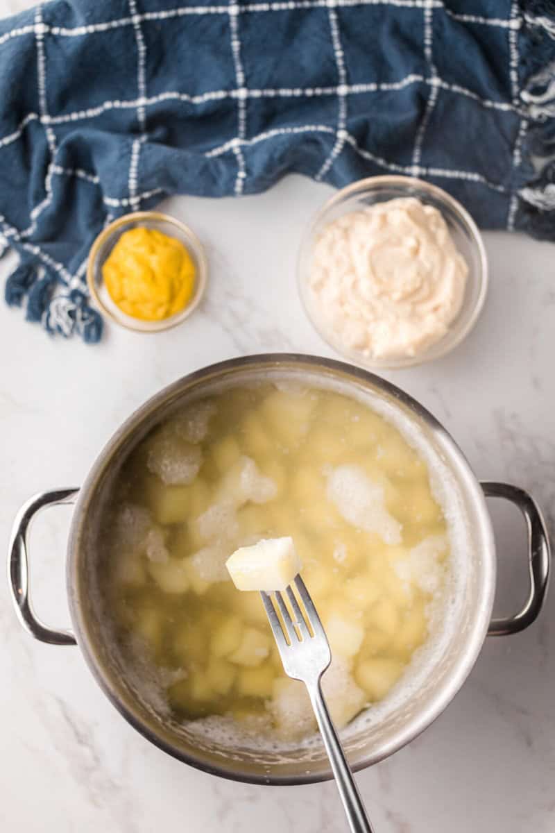 boiling the potatoes in a pot for the potato salad.