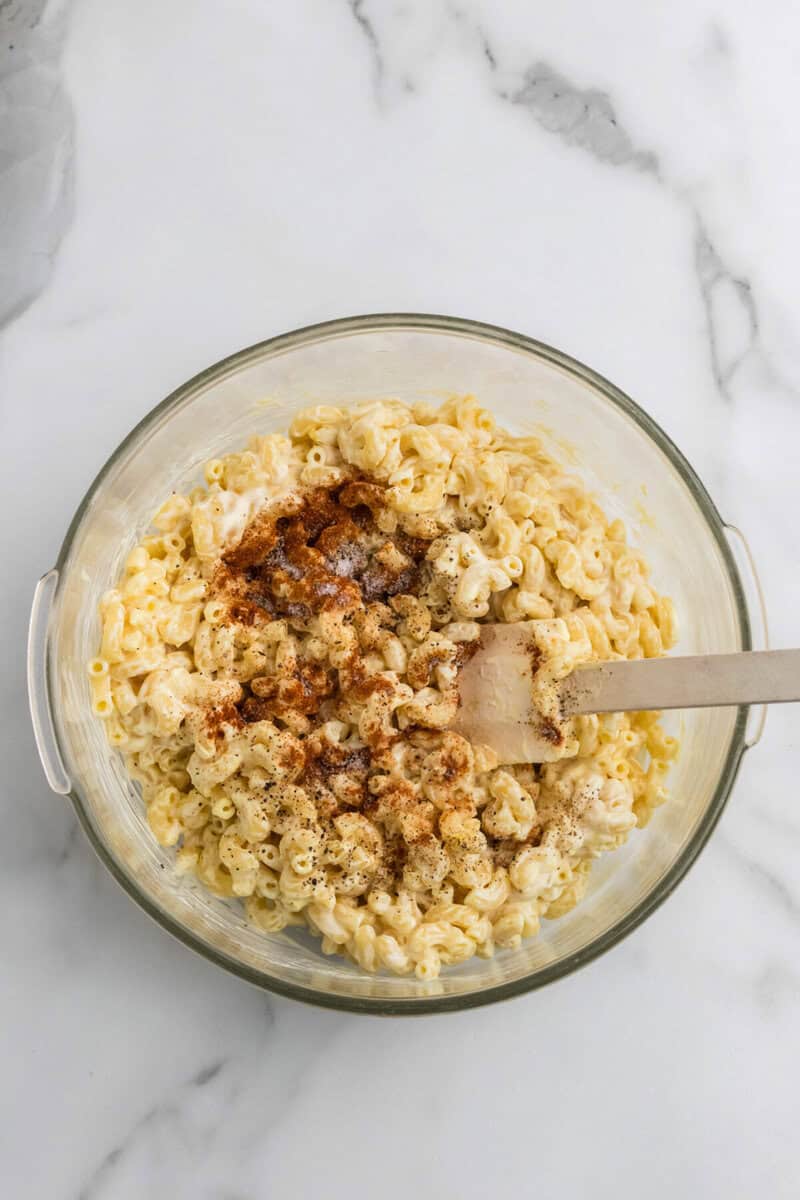 Mixing the seasoning together with the noodles.