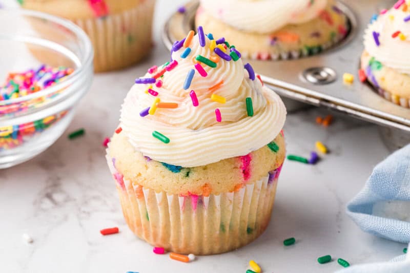 closeup of a finished Funfetti Cupcake frosted and sprinkled.
