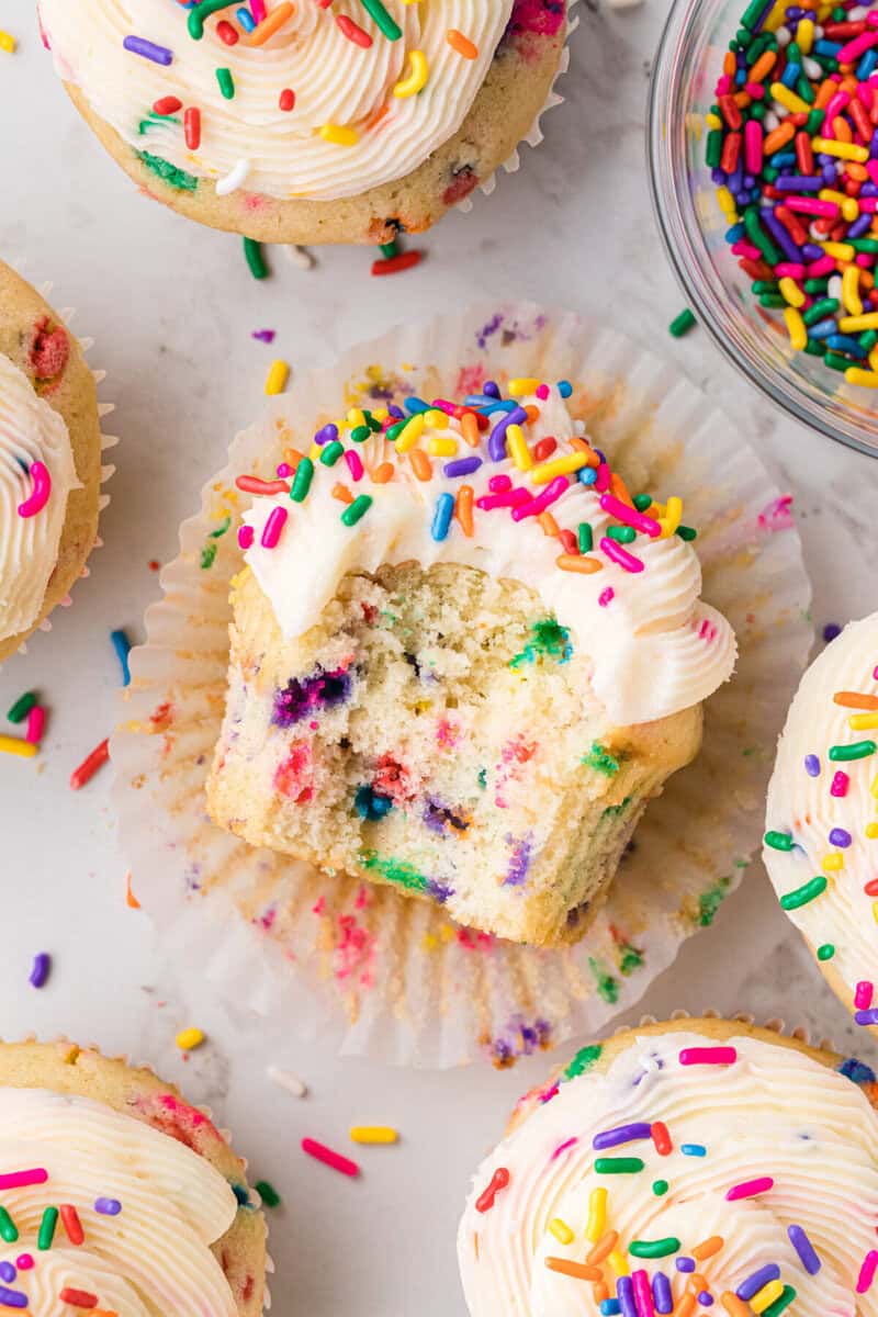 Funfetti Cupcake with a bite taken out of it to show the inside.